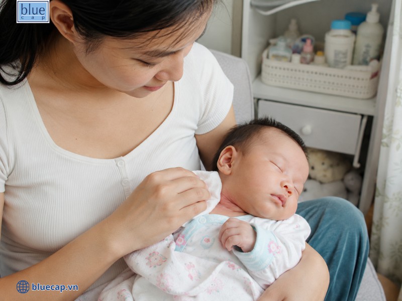 Dùng khăn chấm nhẹ vệ sinh vùng cổ cho trẻ sau khi bú